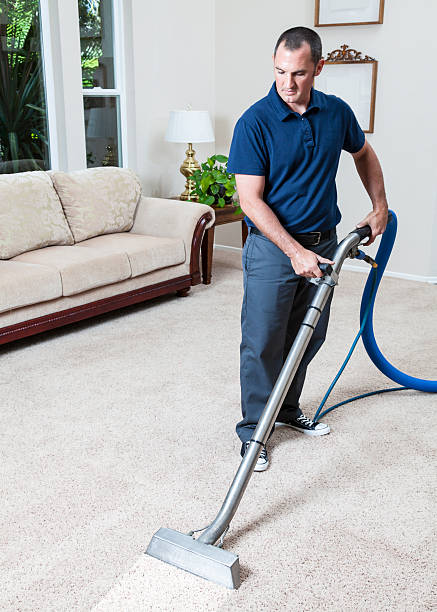 Man cleaning carpets in home